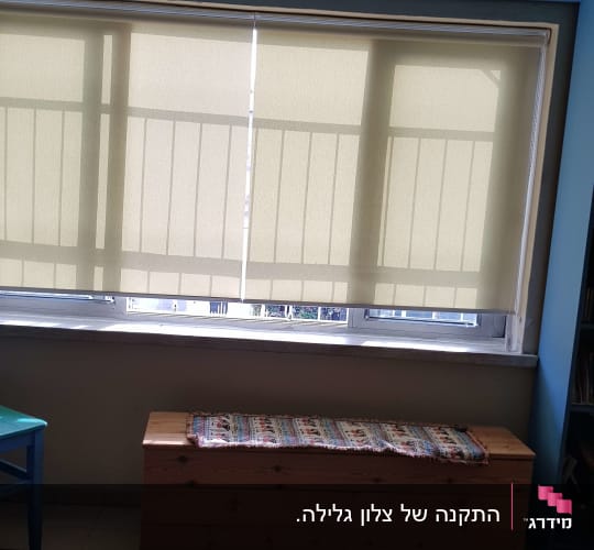 וילון גלילה בהיר על חלון גדול